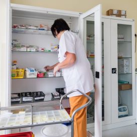 Pielęgniarka pobierająca leki z szafki aptecznej